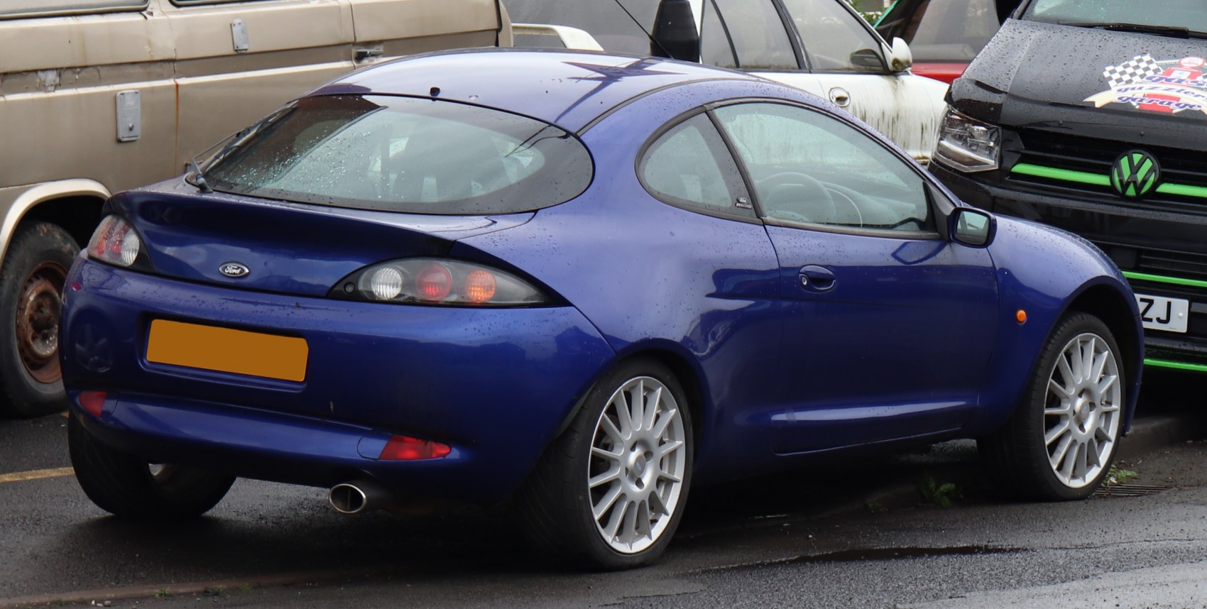 Rear view of a blue sporty coupe with distinctive taillights and alloy wheels