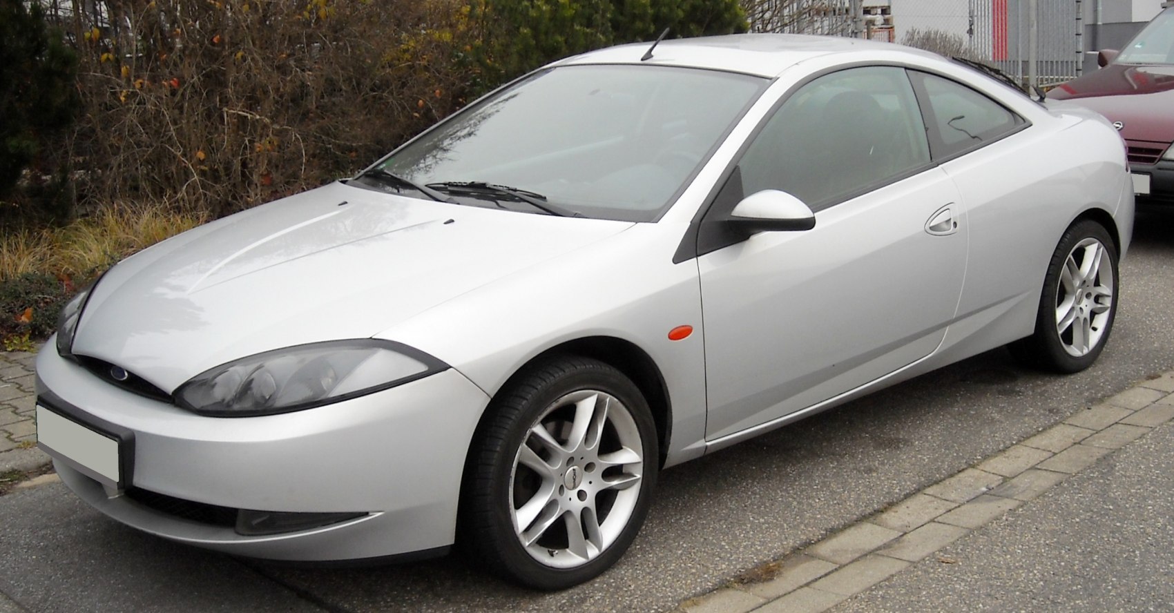 Silver coupe with aerodynamic design and five-spoke alloy wheels.