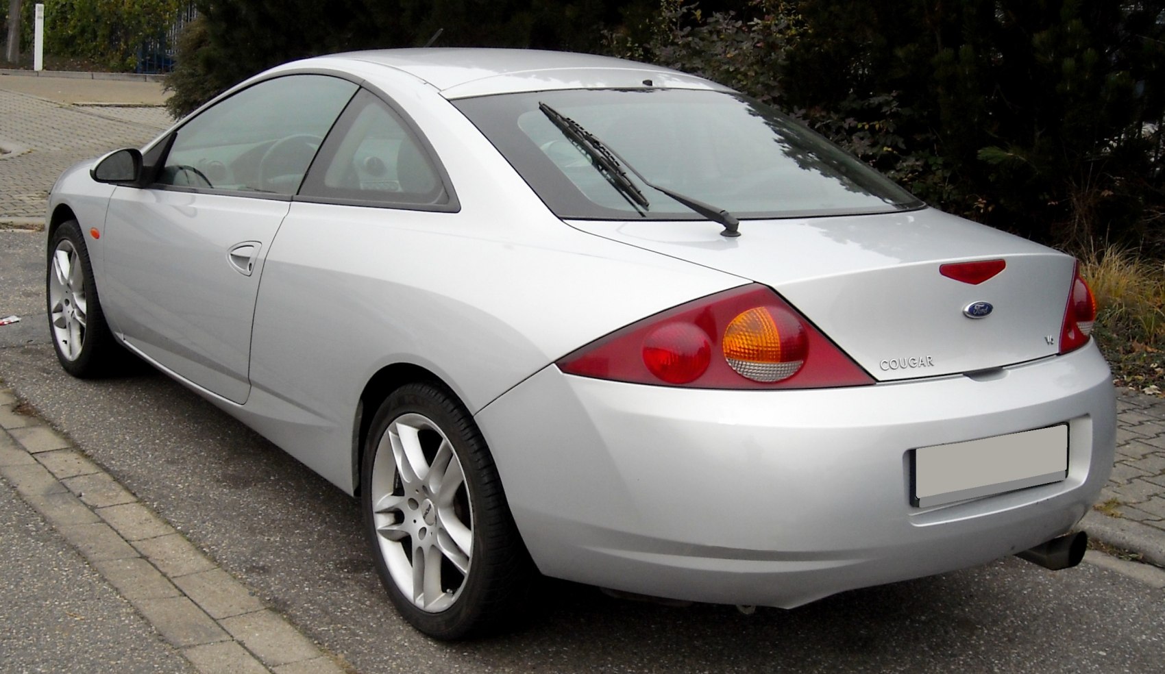 Silver sporty coupe rear side with distinct tail lights and rear windshield wiper