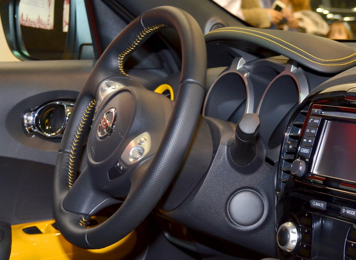 Steering wheel and dashboard close-up with detailed controls and stitching