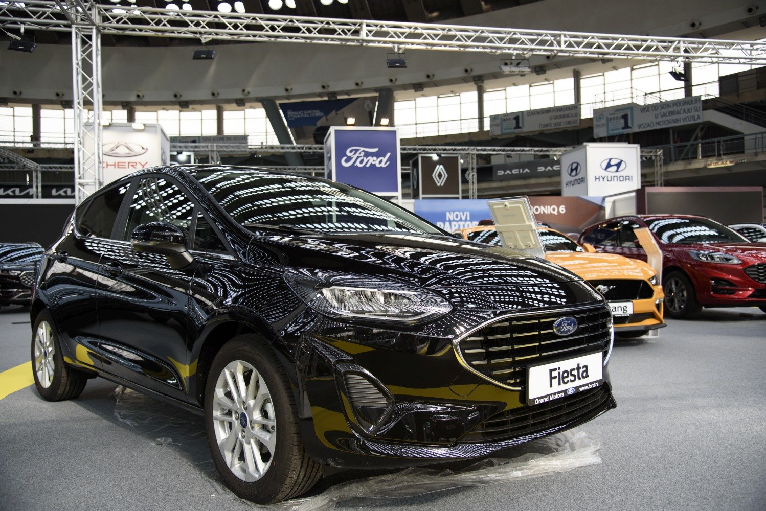 Black glossy 5-door hatchback with prominent grille and sleek headlights.