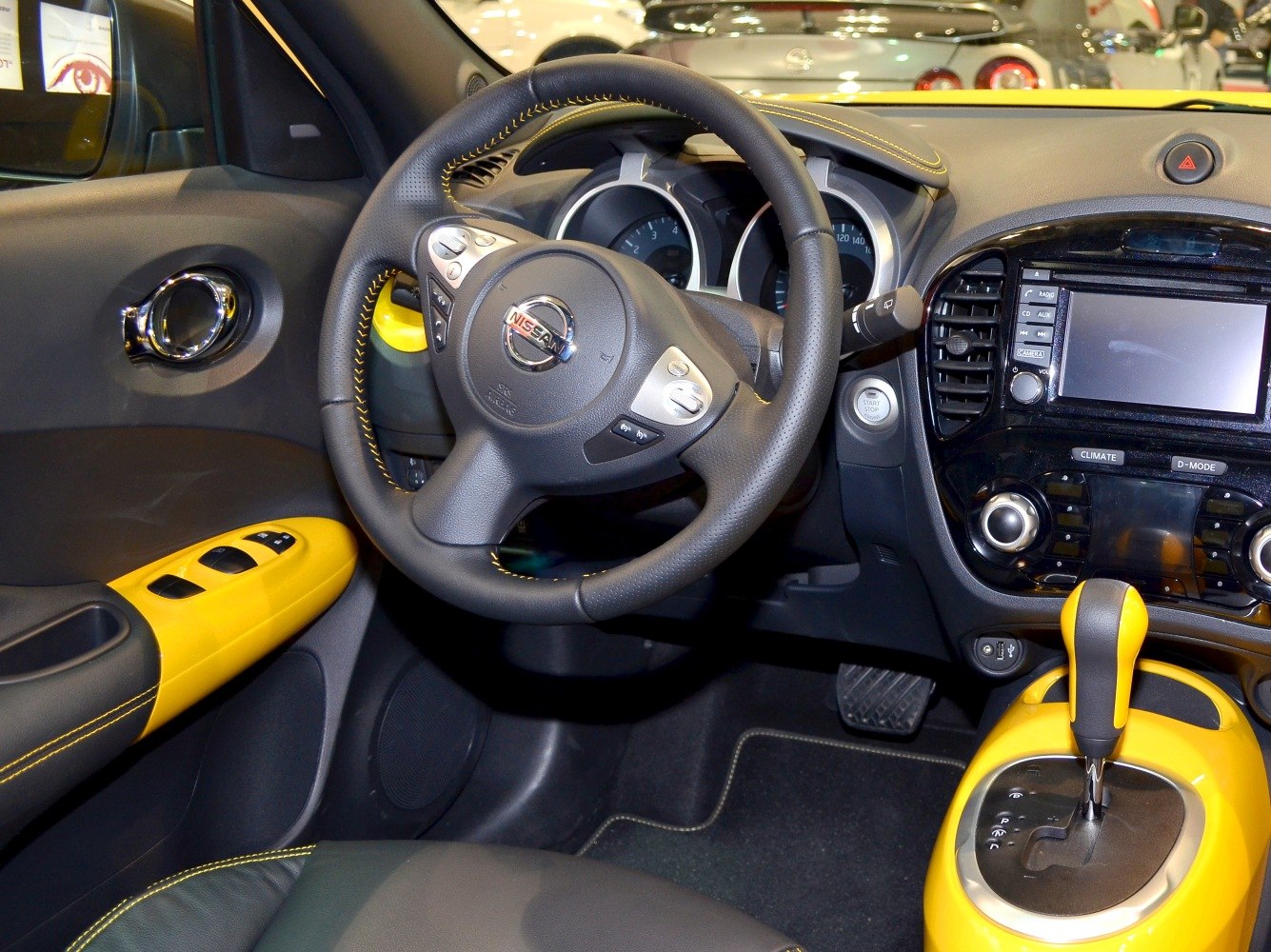Yellow accented steering wheel and gear shift in modern car interior
