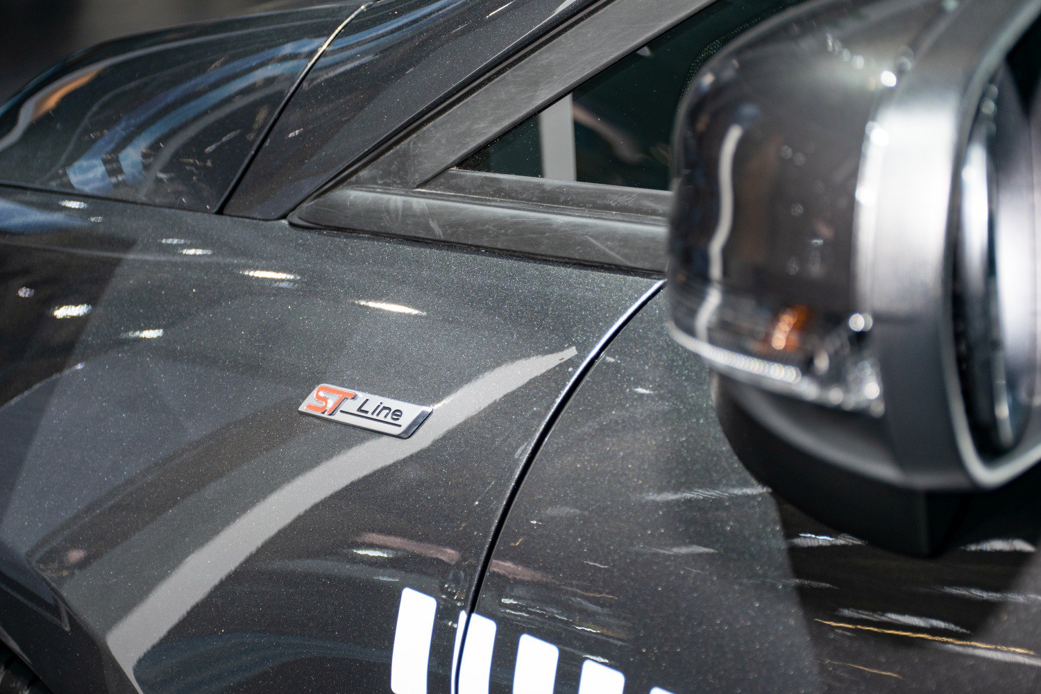 Close-up of ST-Line badge and side mirror with indicator on car body