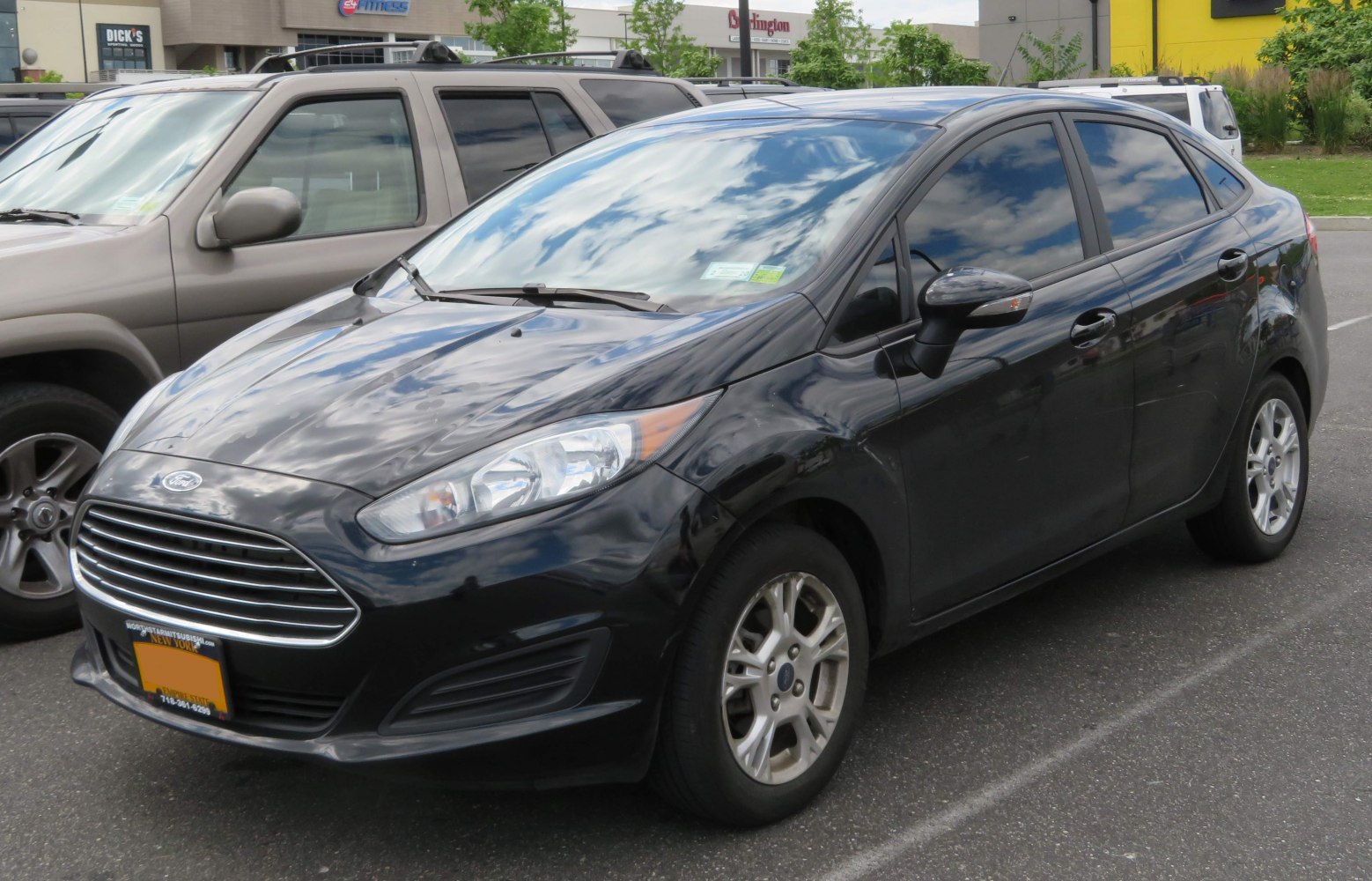 Front and side view of compact sedan with chrome grille and alloy wheels