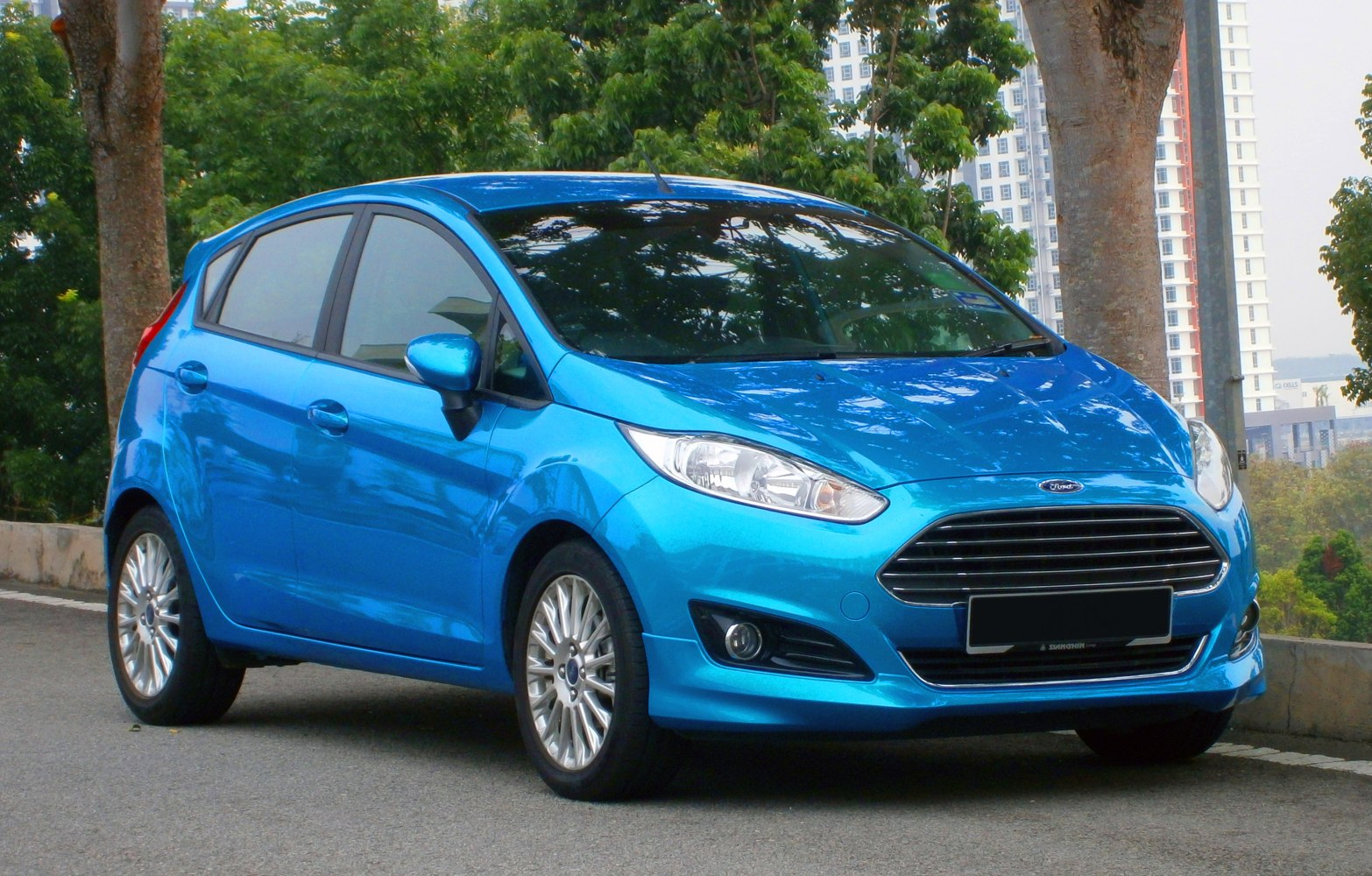 Blue 5-door hatchback with sleek front grille and alloy wheels