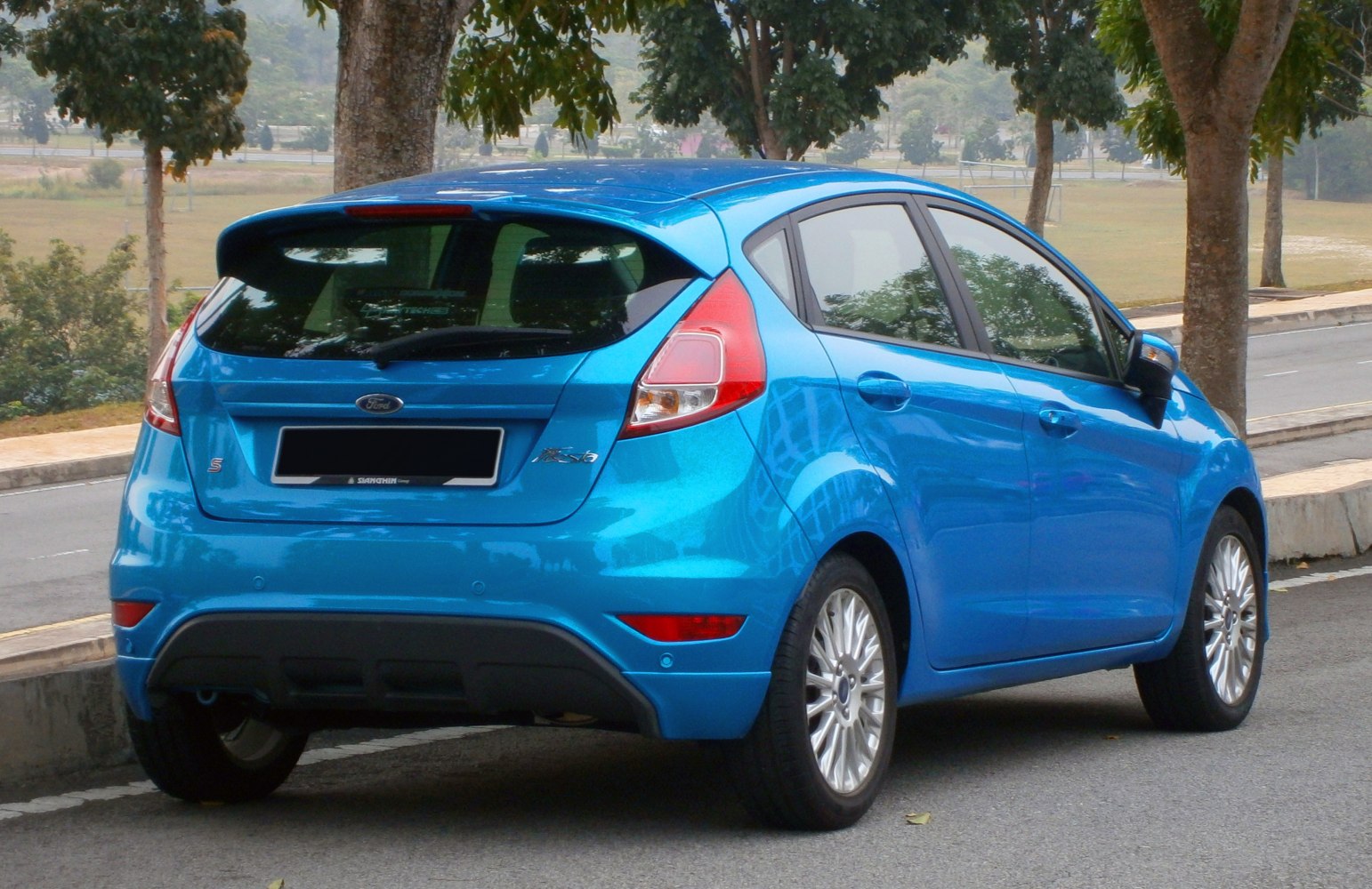 Rear view of a blue 5-door hatchback with distinctive taillights and alloy wheels.