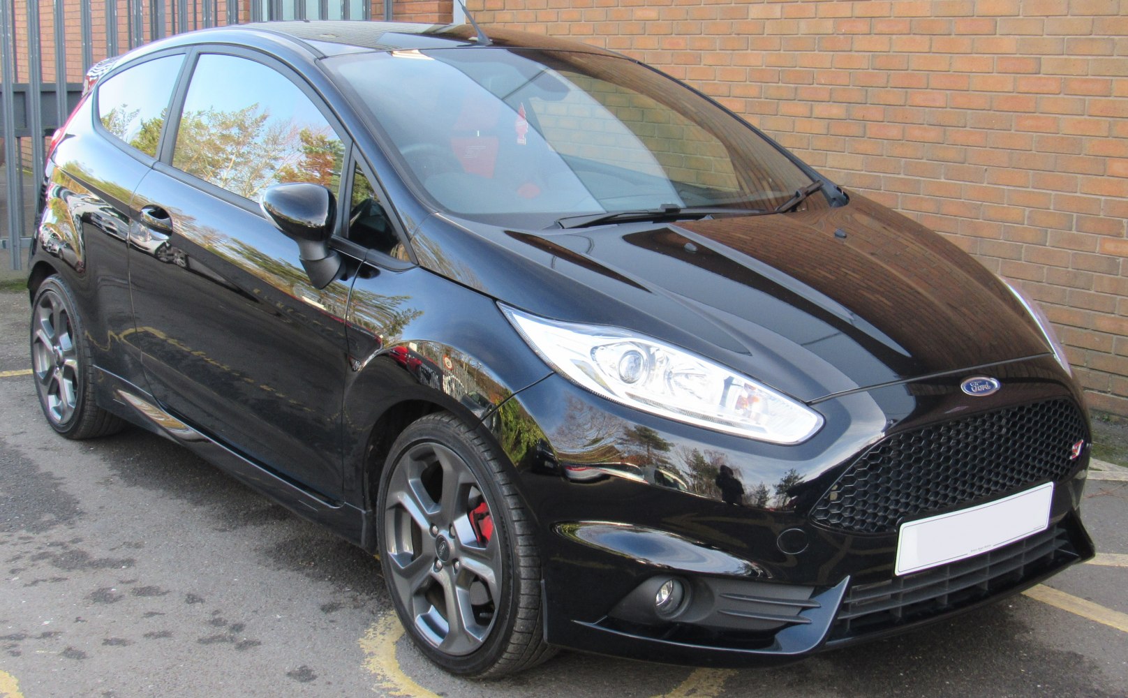 Front side of a black 5-door hatchback with sporty alloy wheels and prominent headlights