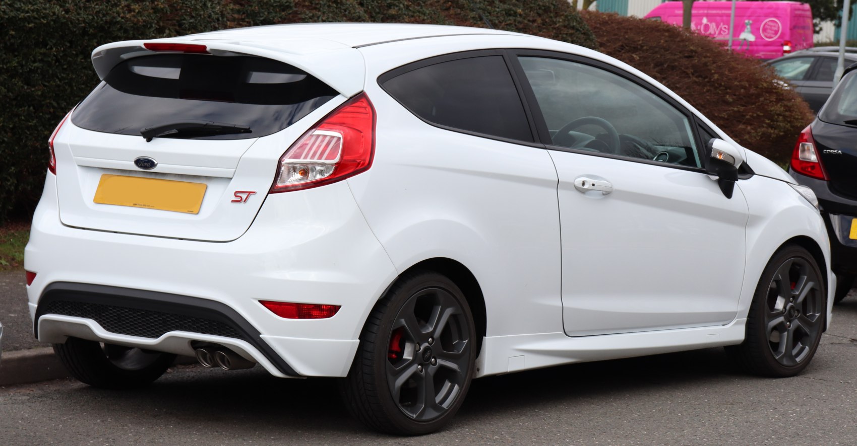 White sporty 3-door hatchback with dual exhaust and dark wheels