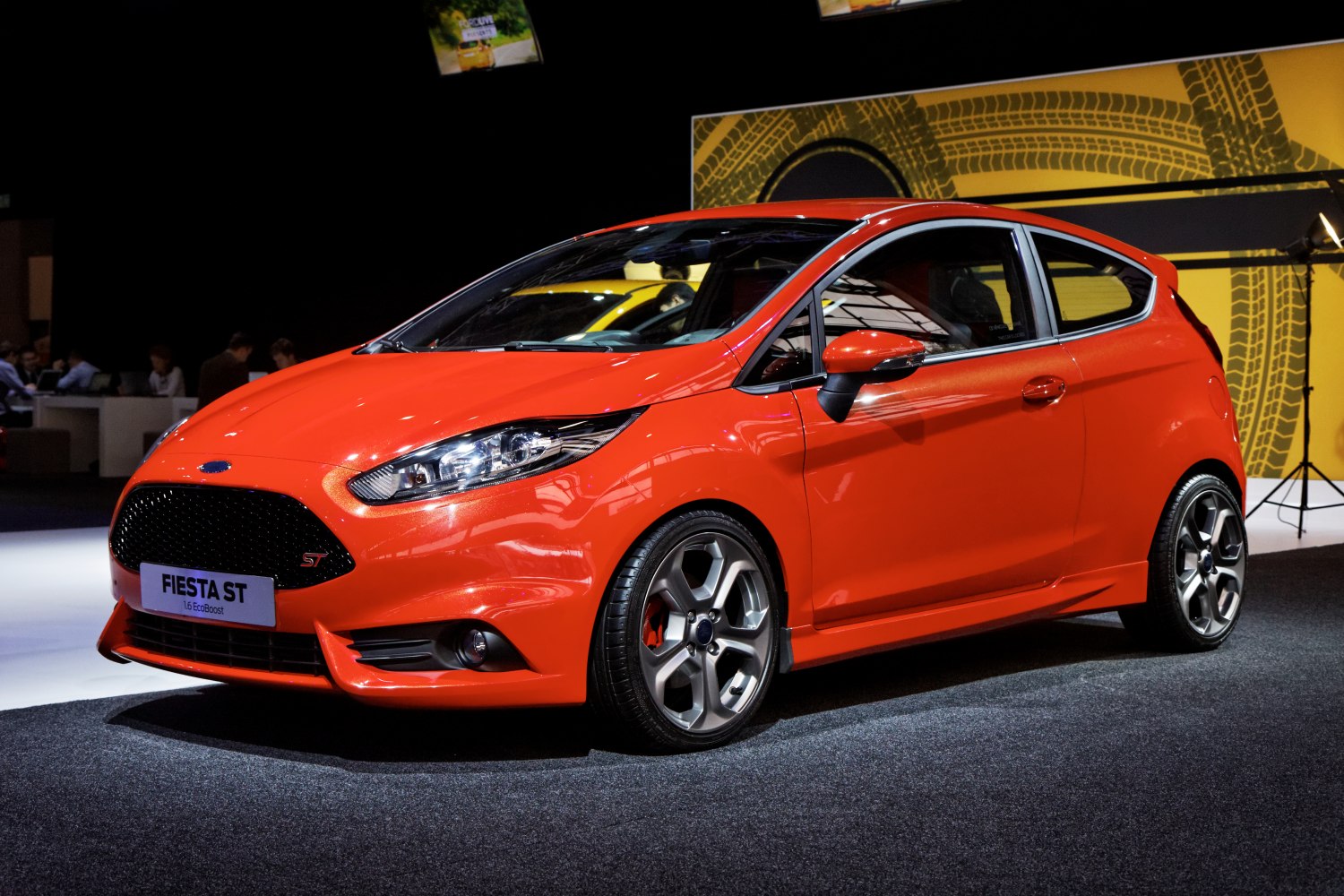 Orange sporty hatchback with aggressive front grille and alloy wheels