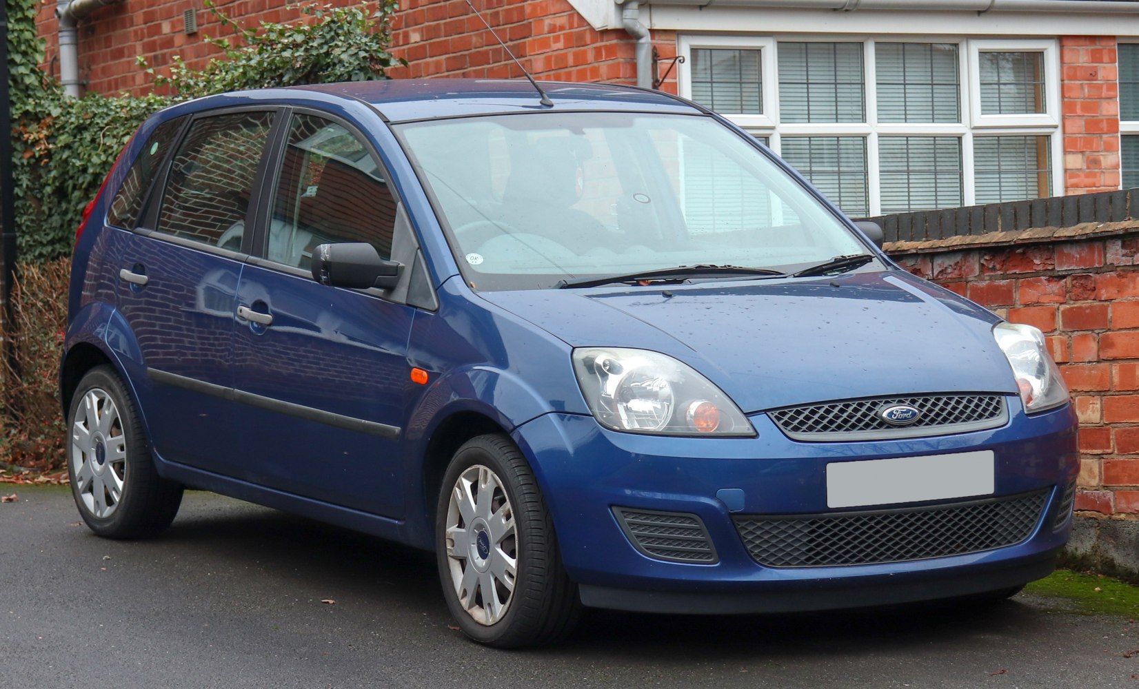 Blue 5-door hatchback front exterior with headlights and grille