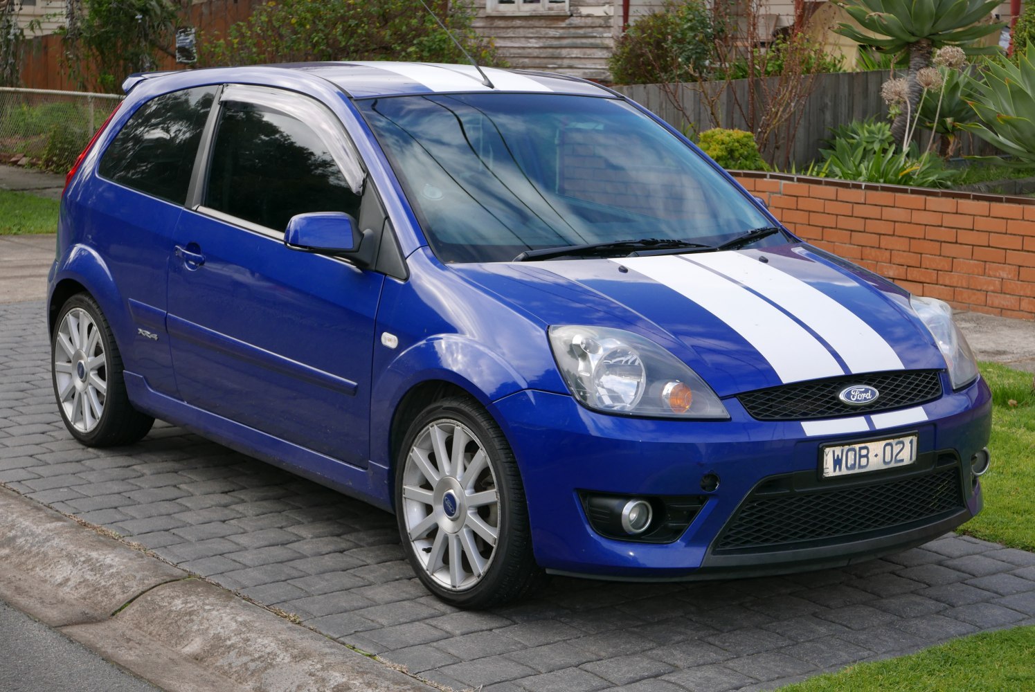 3-door compact hatchback with white racing stripes and alloy wheels