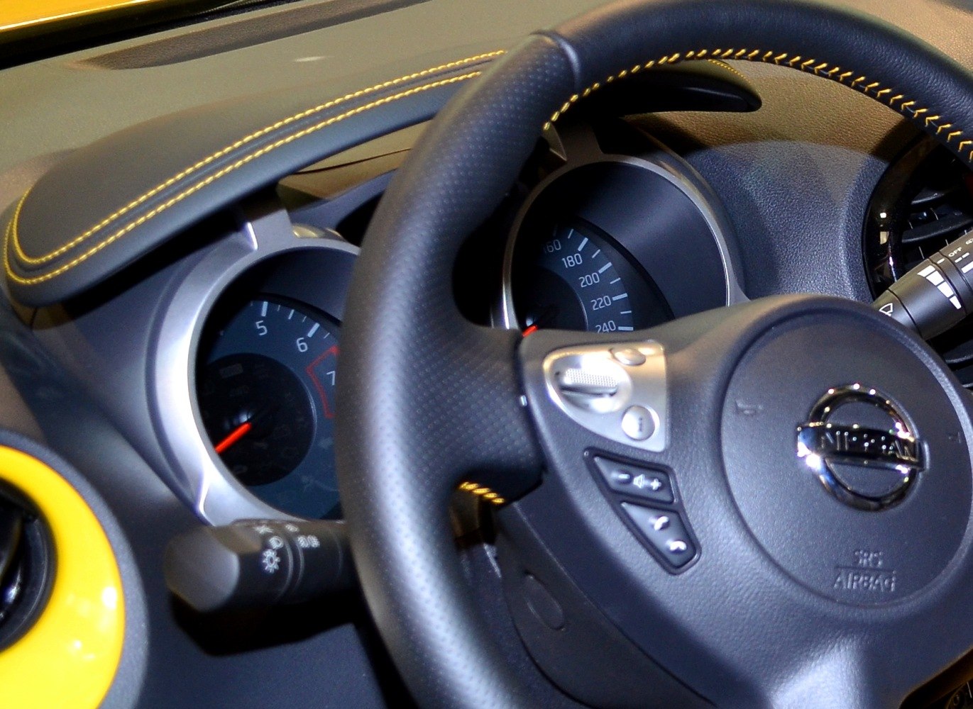 Dashboard and steering wheel with instrument cluster and stitched leather detail