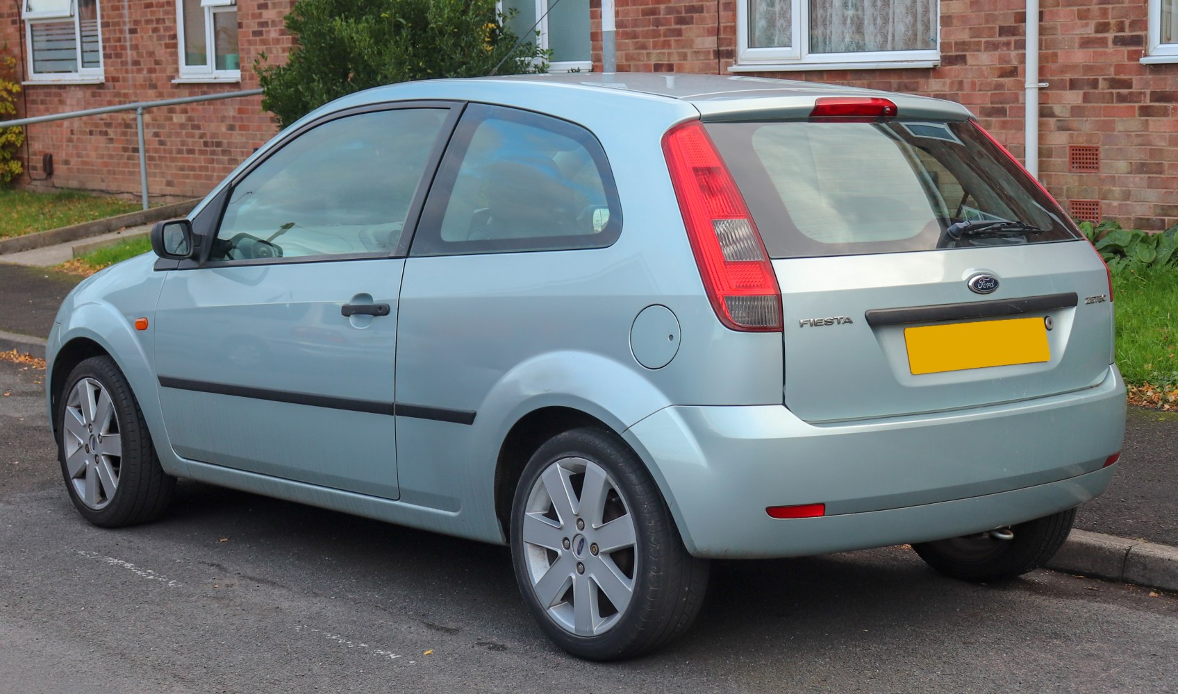 Rear side view of a 3-door hatchback with distinctive vertical taillights and alloy wheels