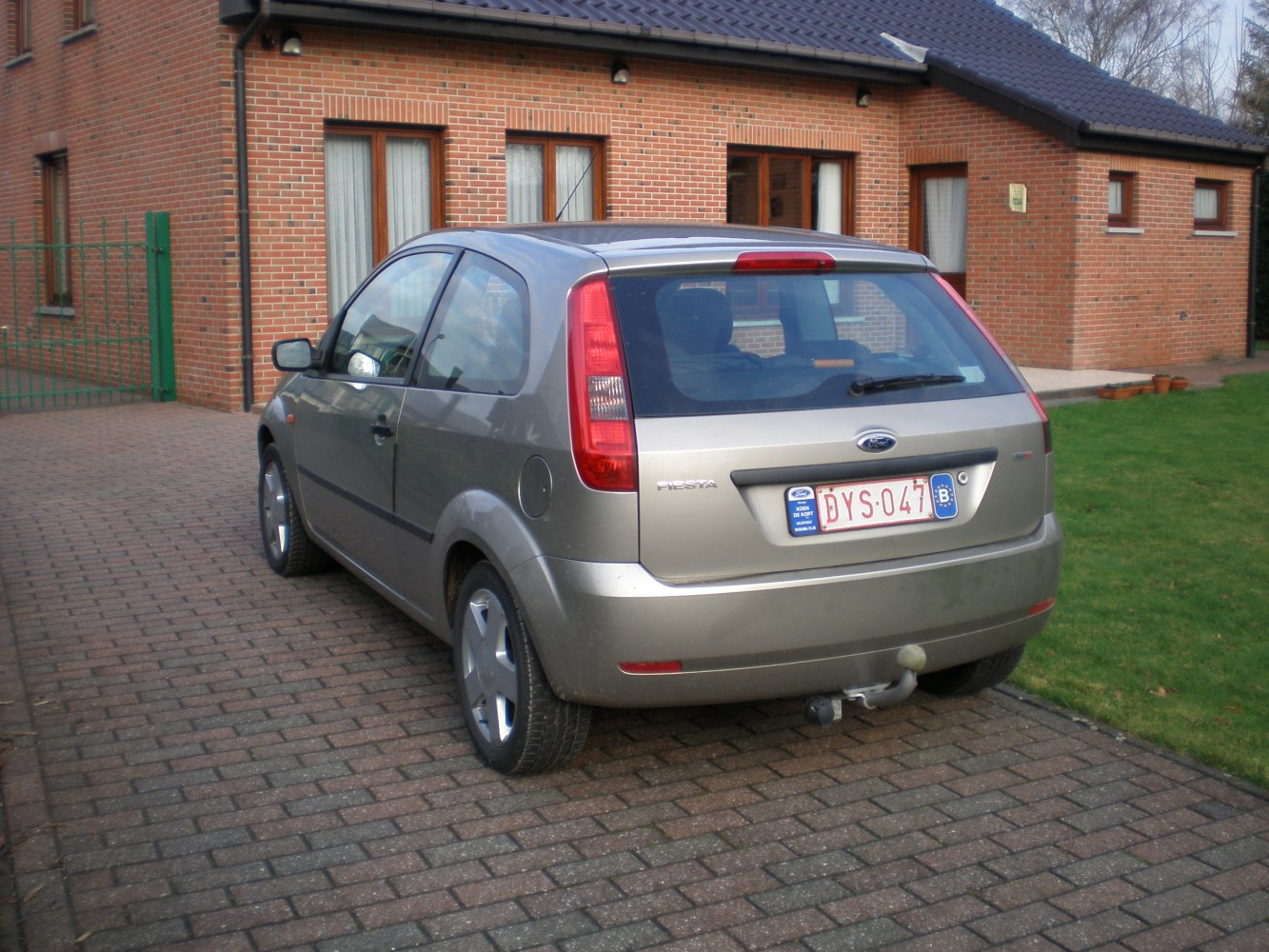 Rear view of a 3 door hatchback with red taillights and tow hitch
