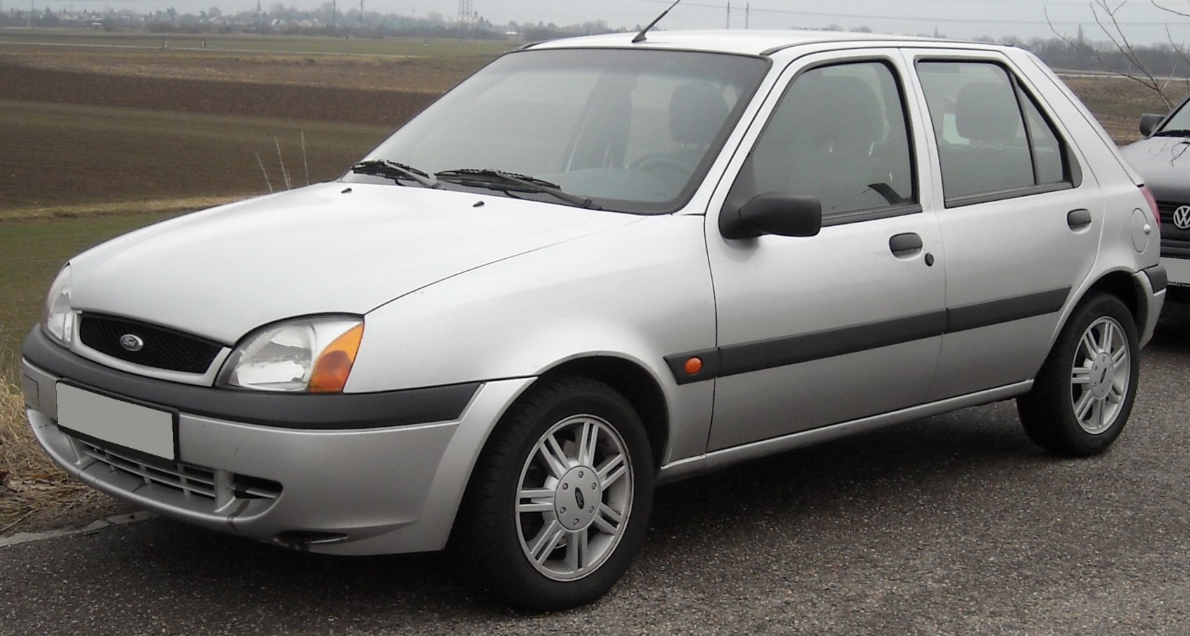 Silver 5-door compact hatchback with alloy wheels and black trim side view