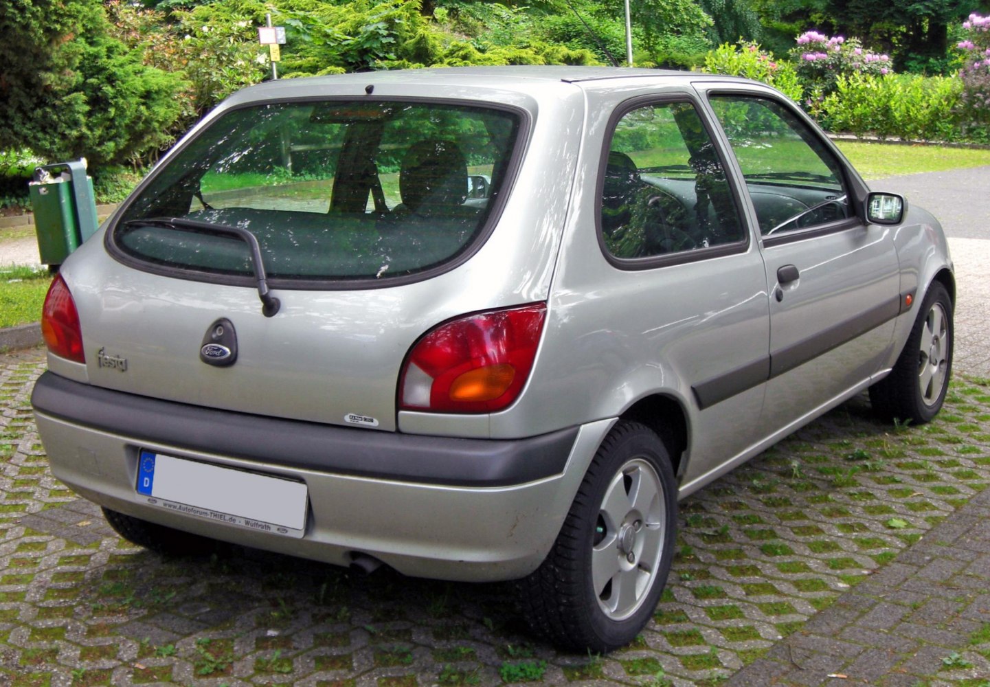 Rear view of a 3-door hatchback with tail lights and rear windshield wiper