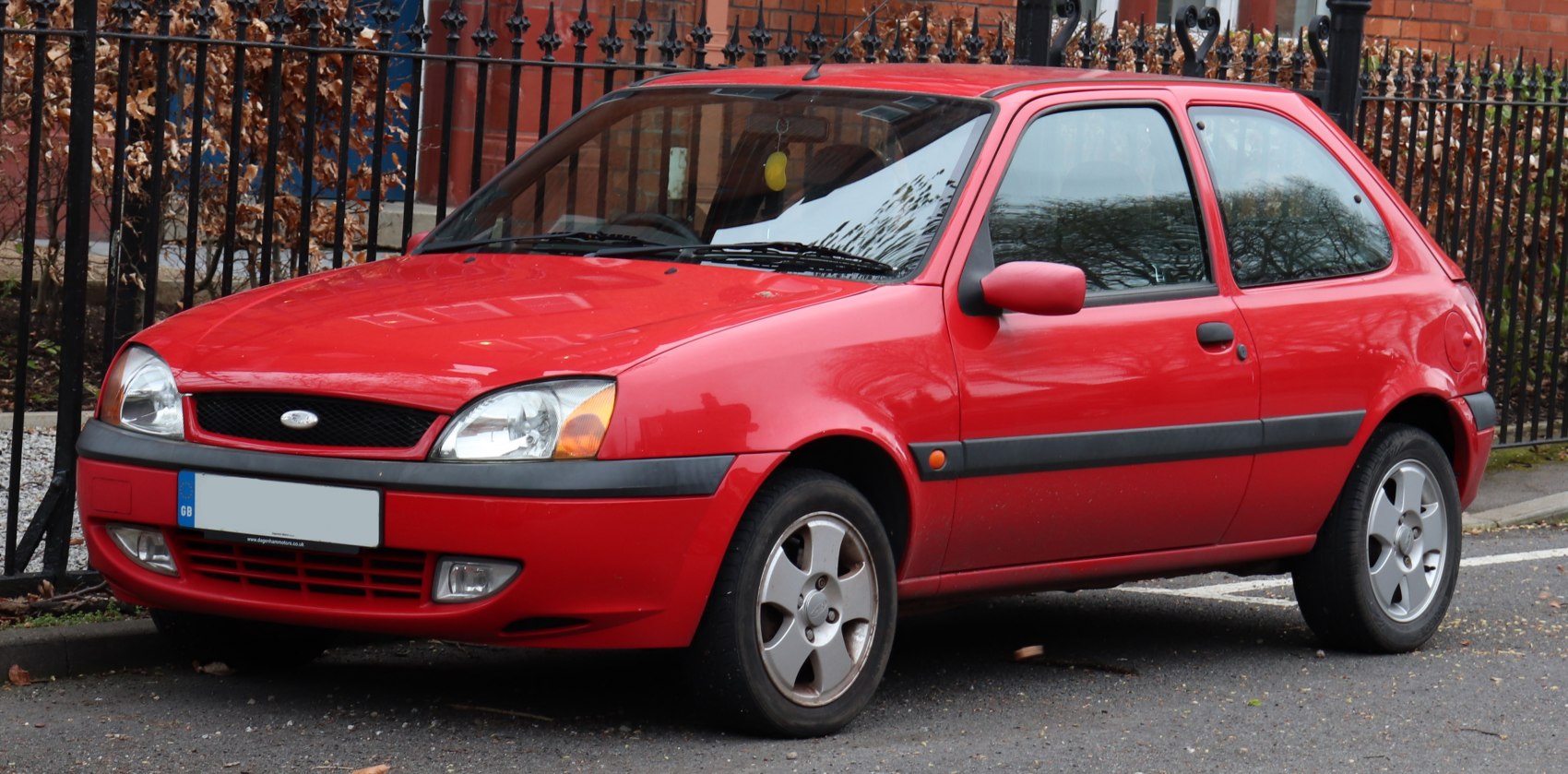 compact three-door red hatchback with alloy wheels