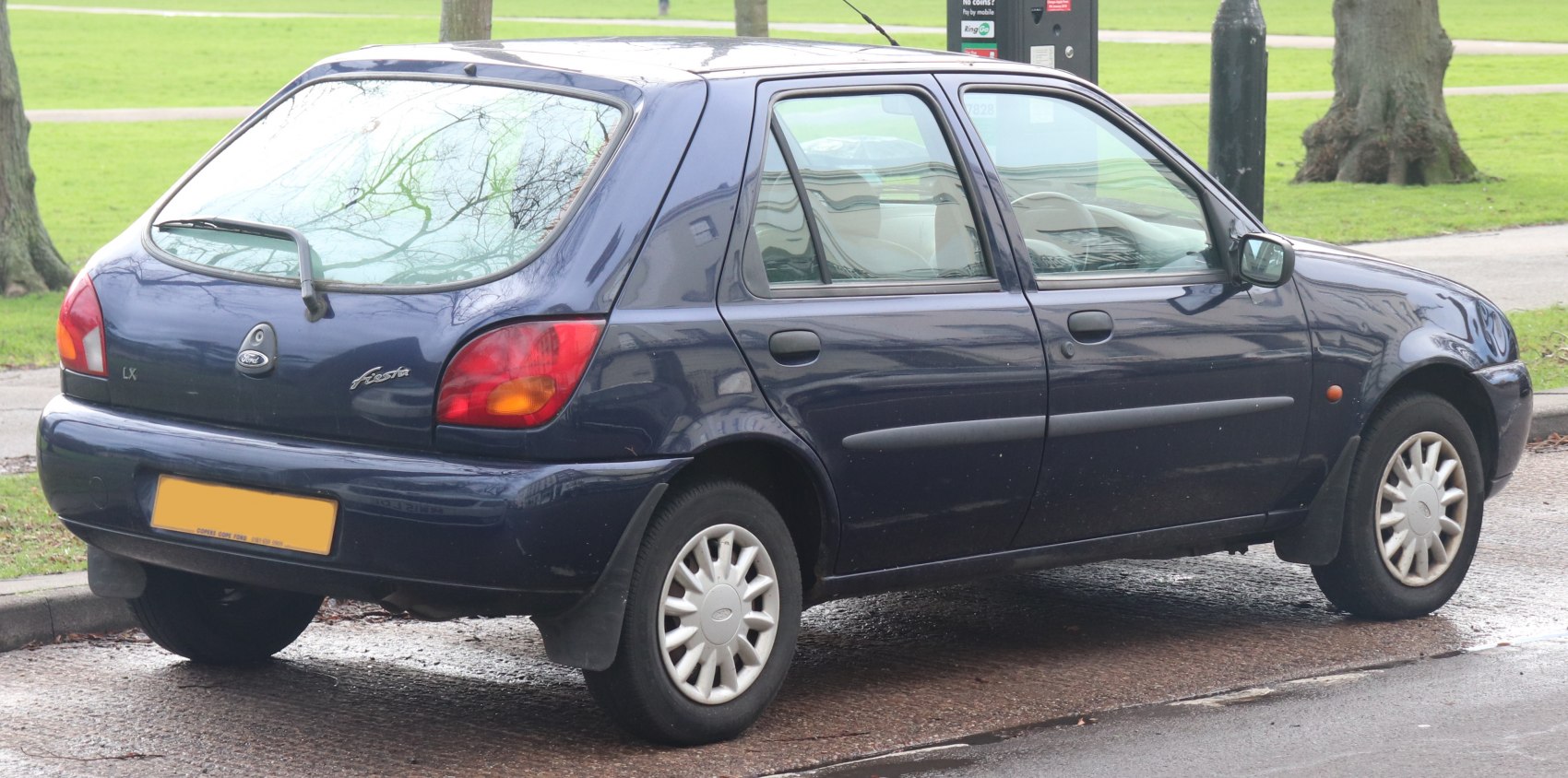 Rear side view of 1990s five-door hatchback with distinct taillights and wagon-style rear window.