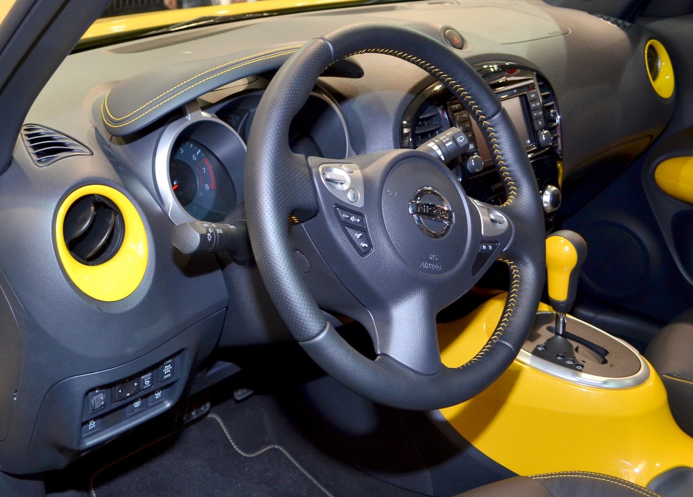 Steering wheel and yellow-accented dashboard with gear lever