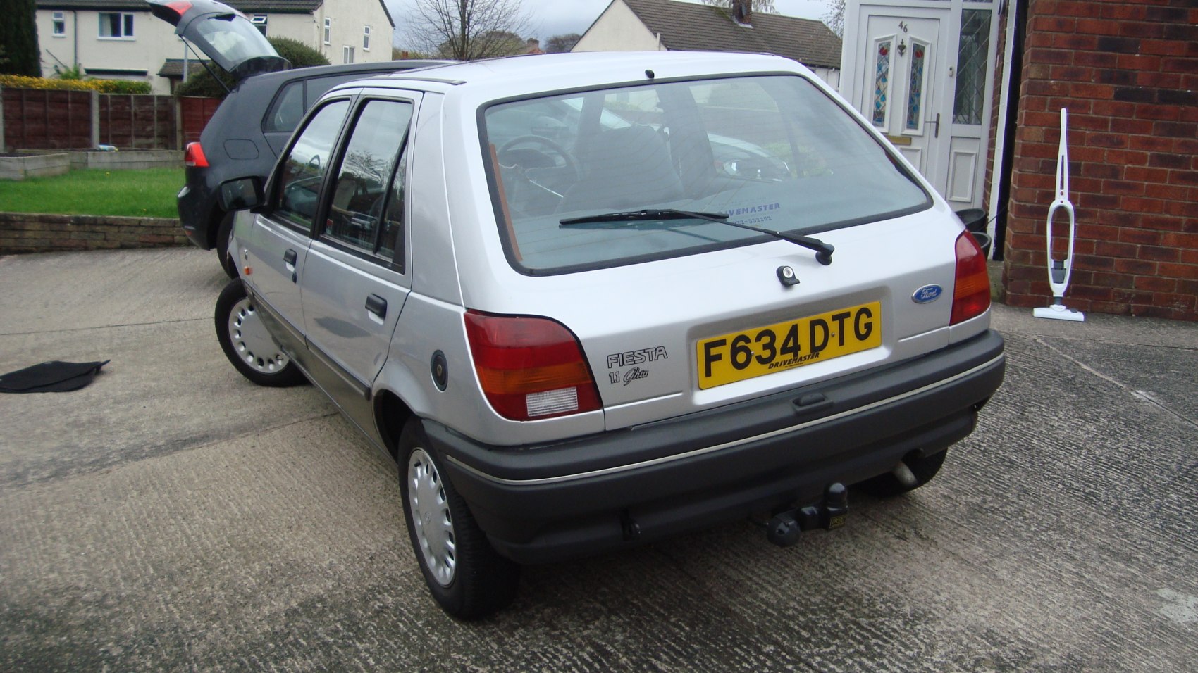 Rear view of a compact 1990s hatchback with distinct tail lights and rear windshield wiper