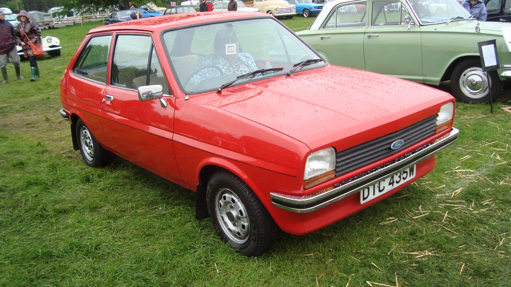 Front side view of red 1970s compact hatchback with chrome bumper.