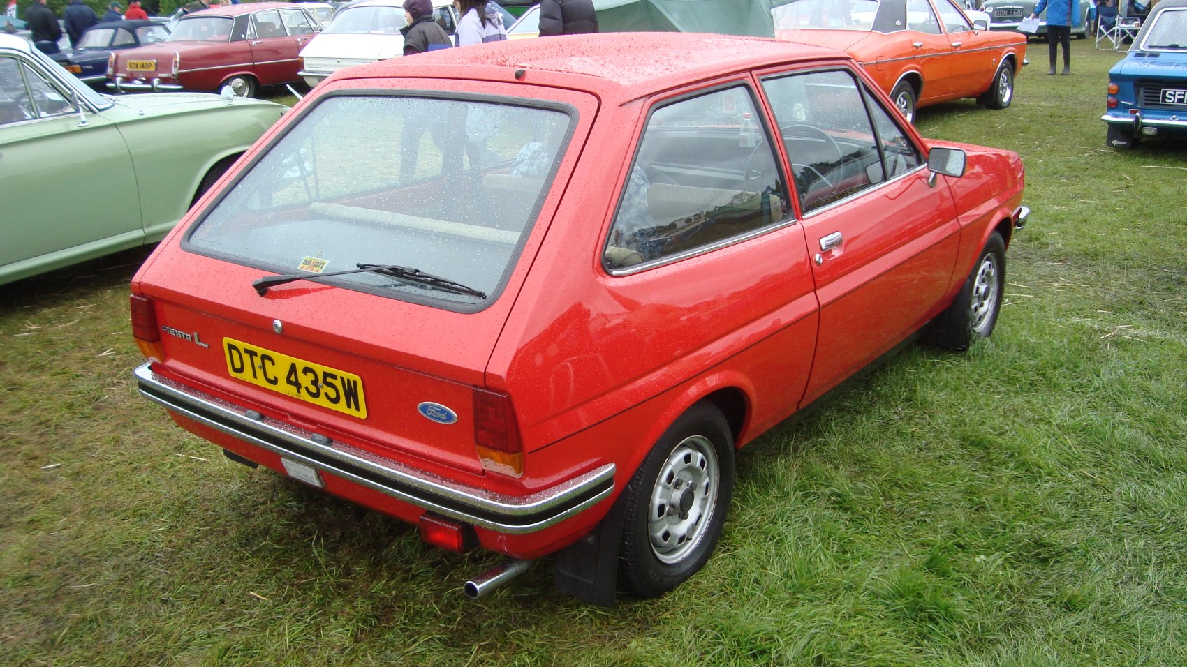 Red vintage hatchback rear 3-quarter view, chrome bumper, retro taillights.