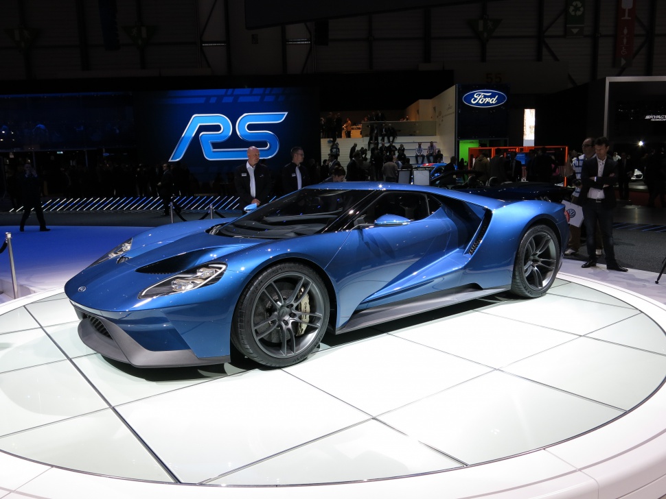Blue aerodynamic sports coupe with prominent front headlights and sleek alloy wheels.