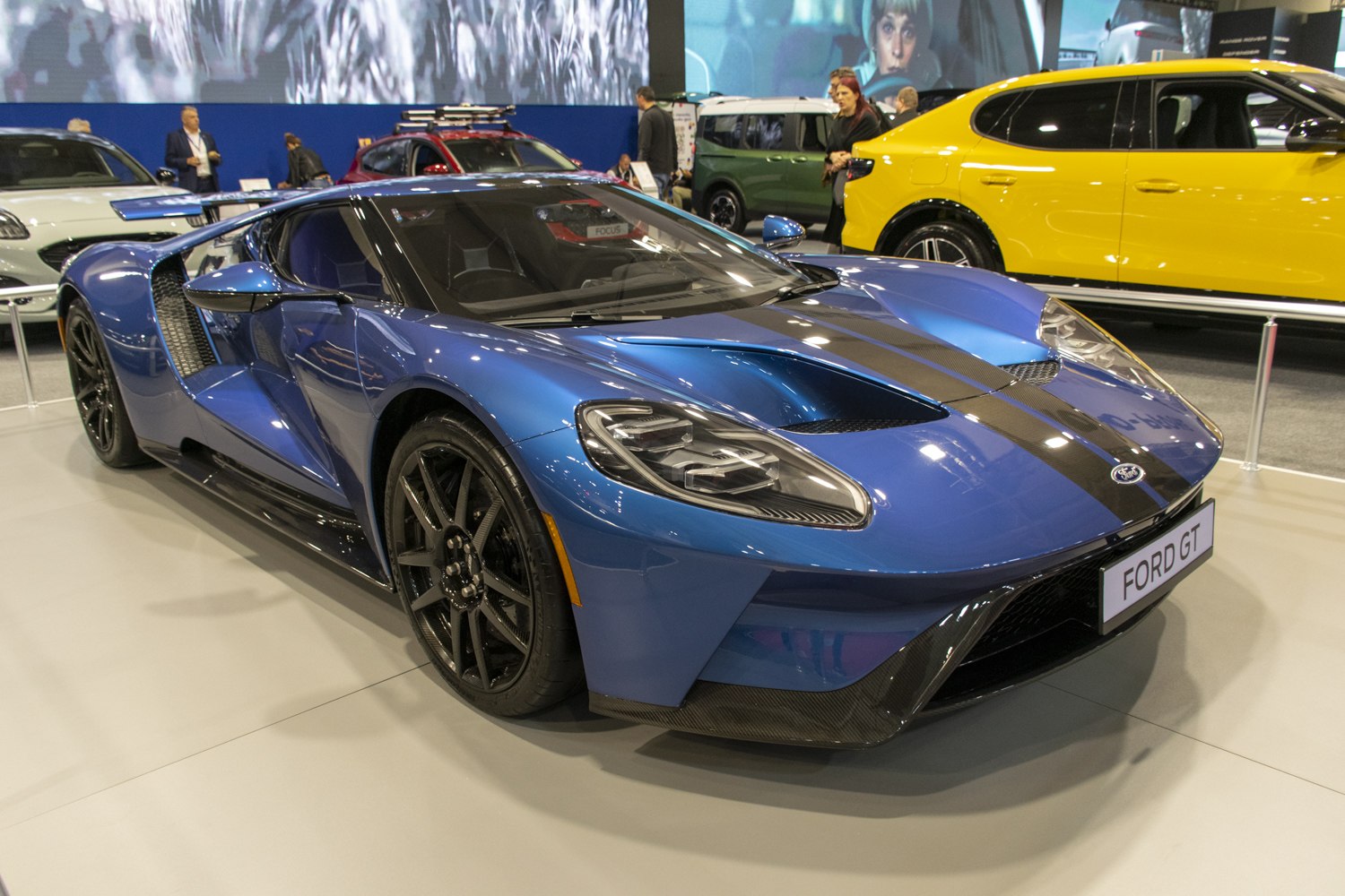 Blue sleek sports car with aerodynamic design and carbon fiber accents