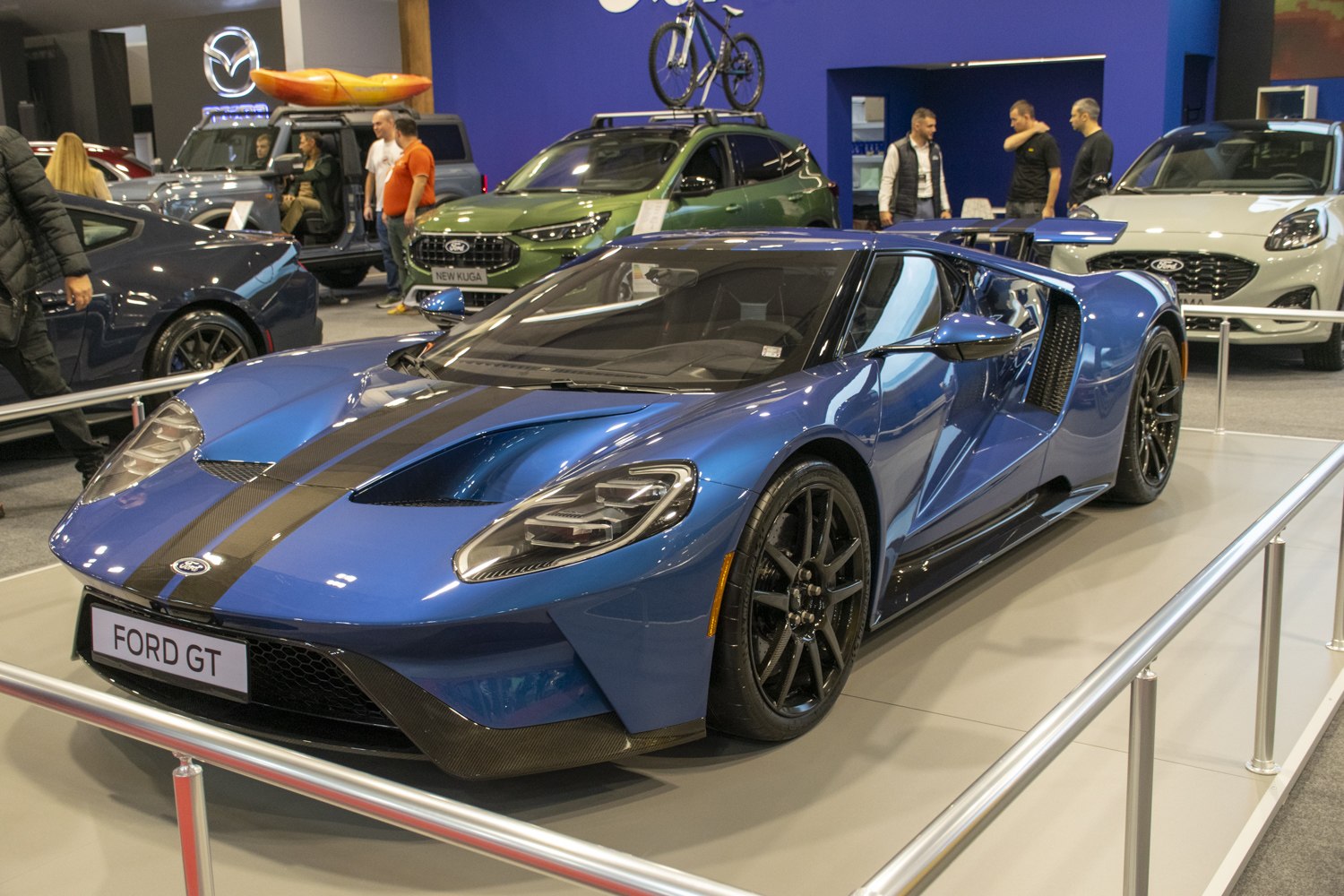 Blue sports supercar with black racing stripes and aerodynamic design