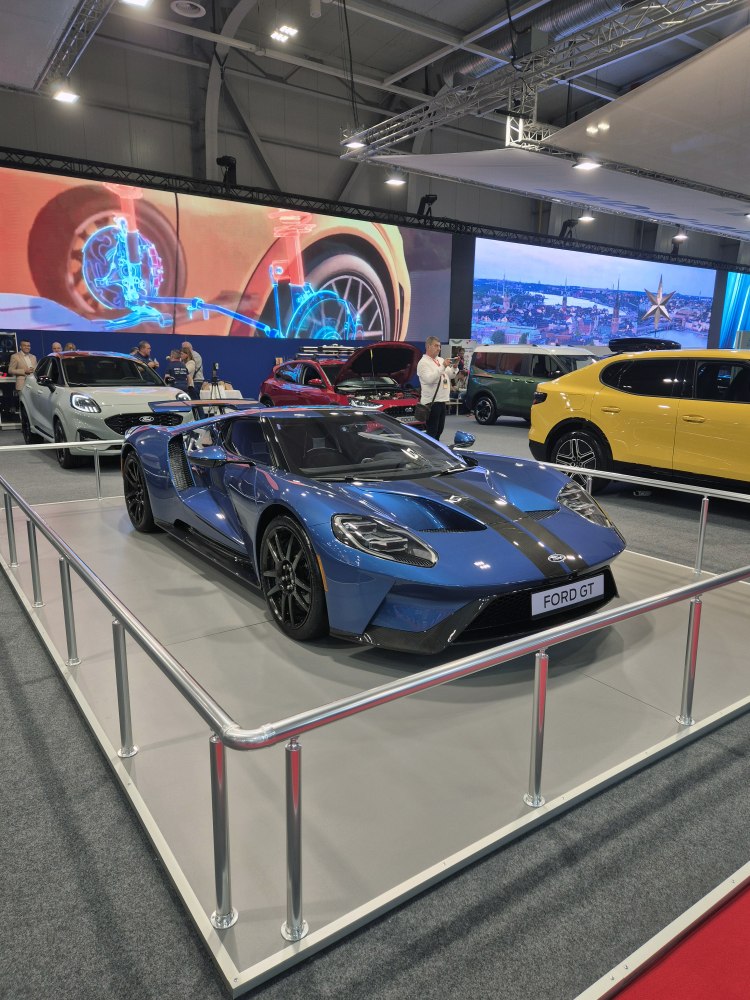 Blue sports car with black racing stripe and aerodynamic front design