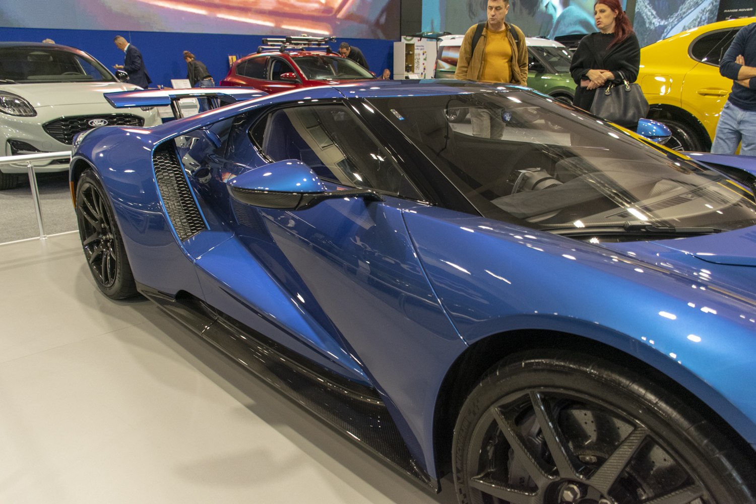 Aerodynamic blue sports car side with rear spoiler and black wheels