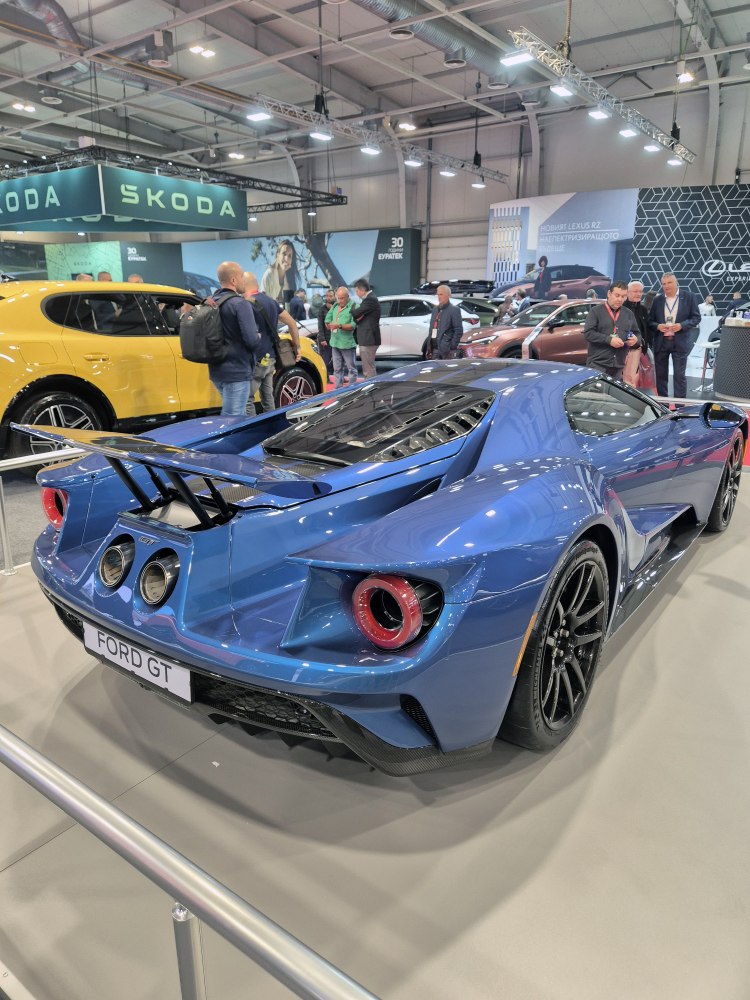 Rear view of a sports car with large aerodynamic wing and circular taillights