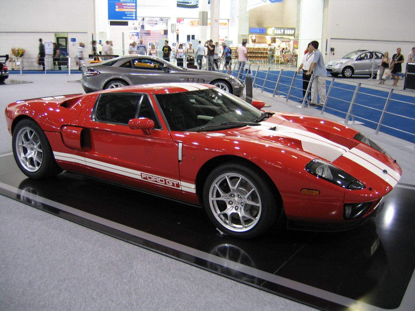 2005 red mid-engine sports car with white racing stripes and sleek aerodynamic design