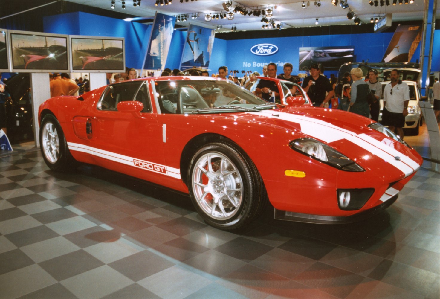 Red sports car with white racing stripe and silver alloy wheels