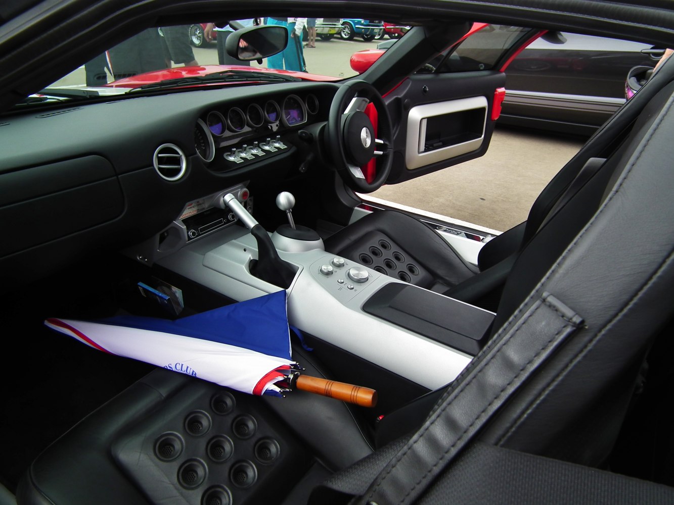 Manual gear shift, dashboard gauges, black leather seats