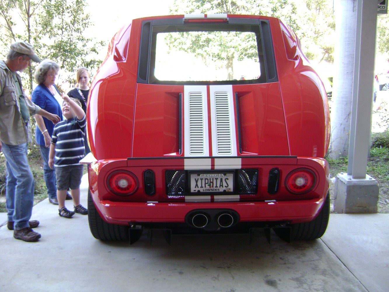 Rear view with dual exhaust, racing stripes, and sporty tail lights