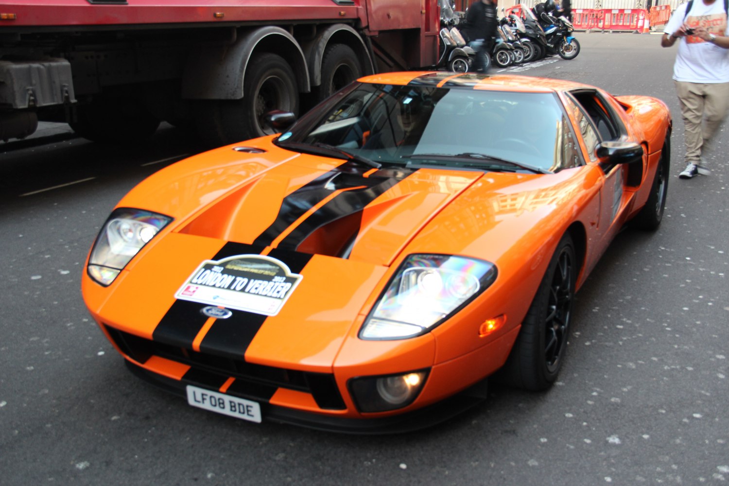 Orange sports car with black racing stripe and aerodynamic shape