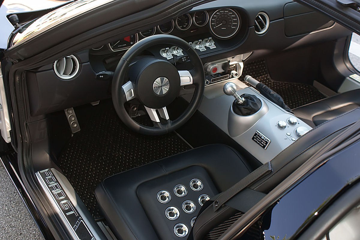Manual gear shifter and circular seat vents in a sporty car interior