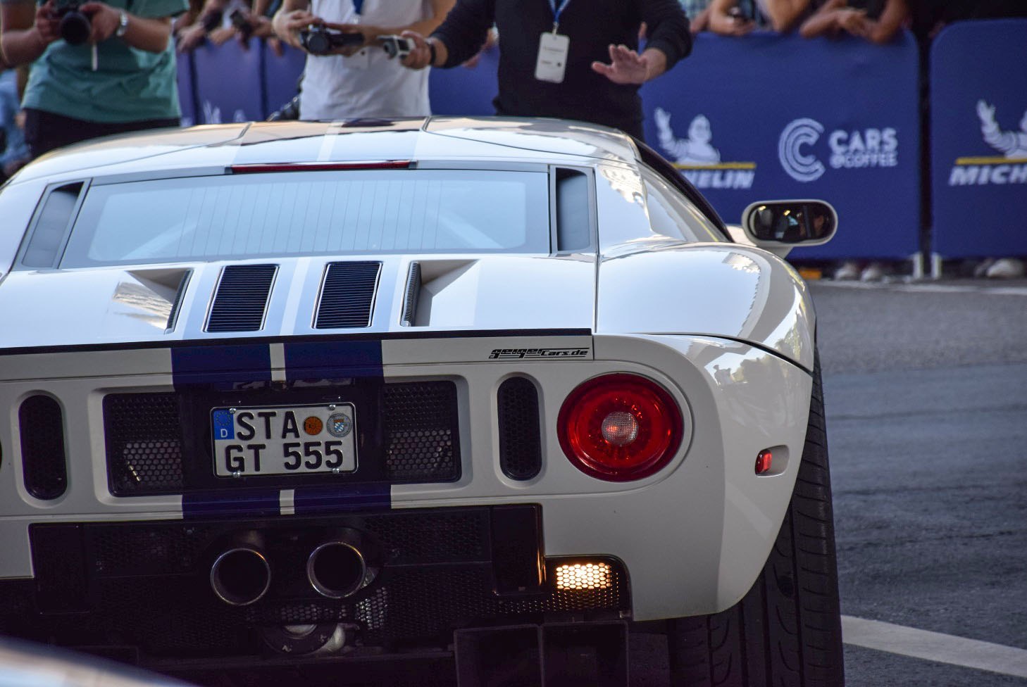 Rear view featuring dual exhaust, round taillights, and racing stripes.