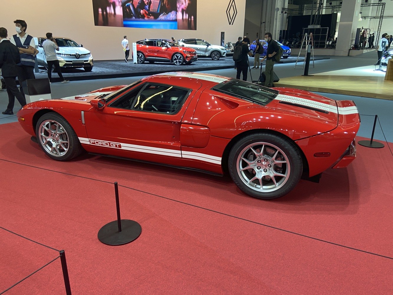 Red classic sports car with white racing stripes and aerodynamic design