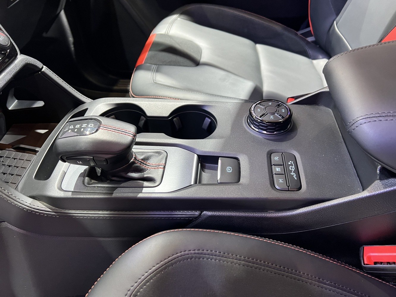 Gear shift lever and control dial with cup holders in vehicle interior
