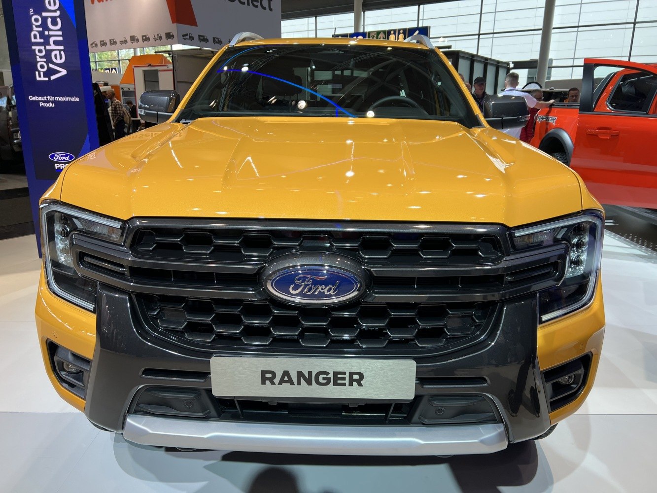 Front close-up of bold grille and headlights on a yellow pickup truck