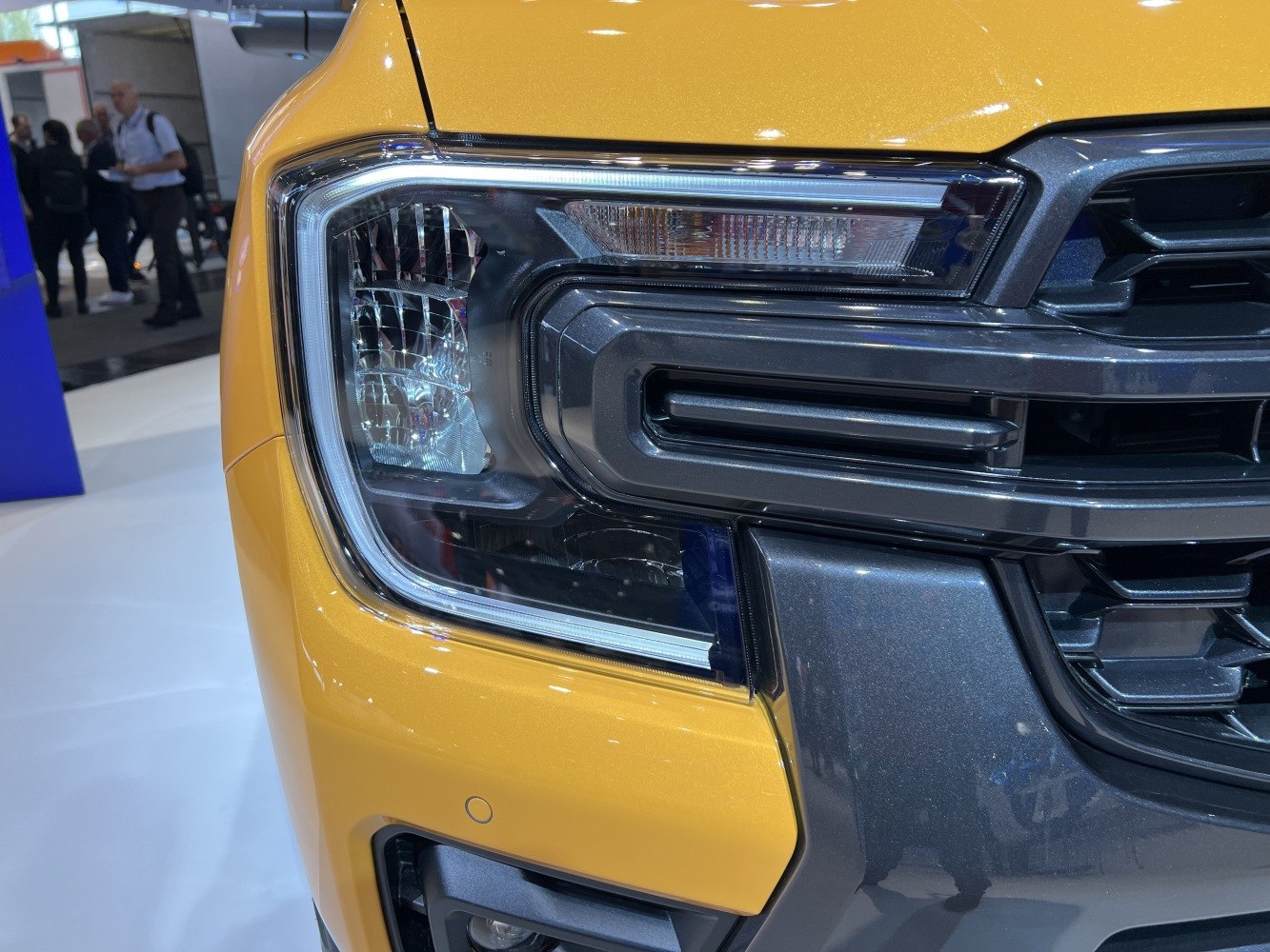 Close-up of front headlight and grille design on a vehicle.