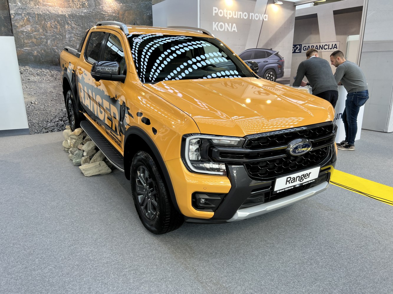 Front side view of rugged yellow double cab pickup with aggressive grille