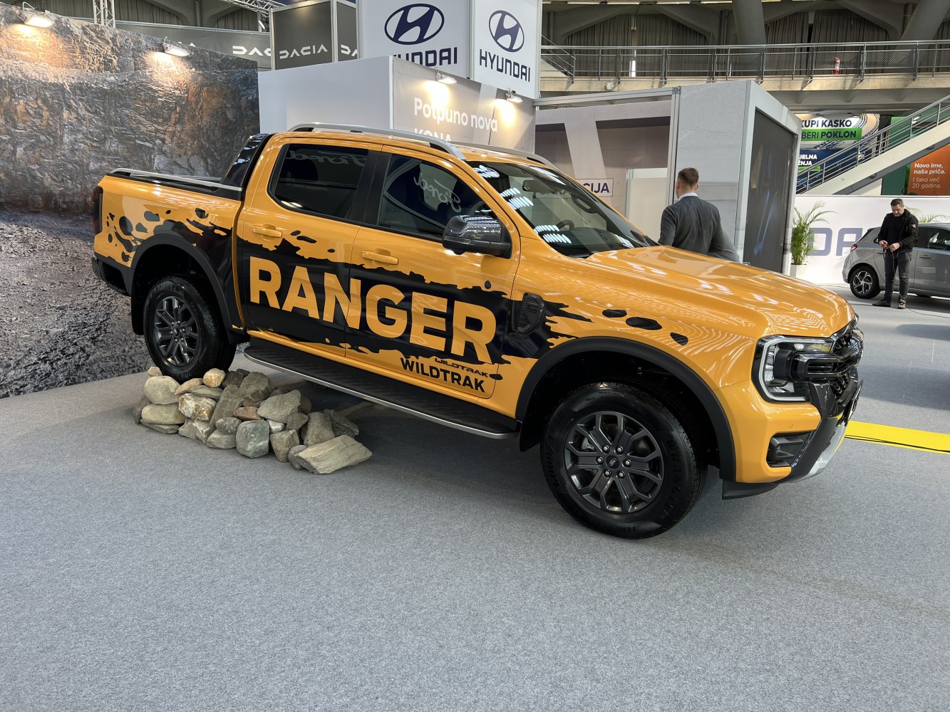 Yellow pickup truck with bold 'RANGER' decal and off-road stance.