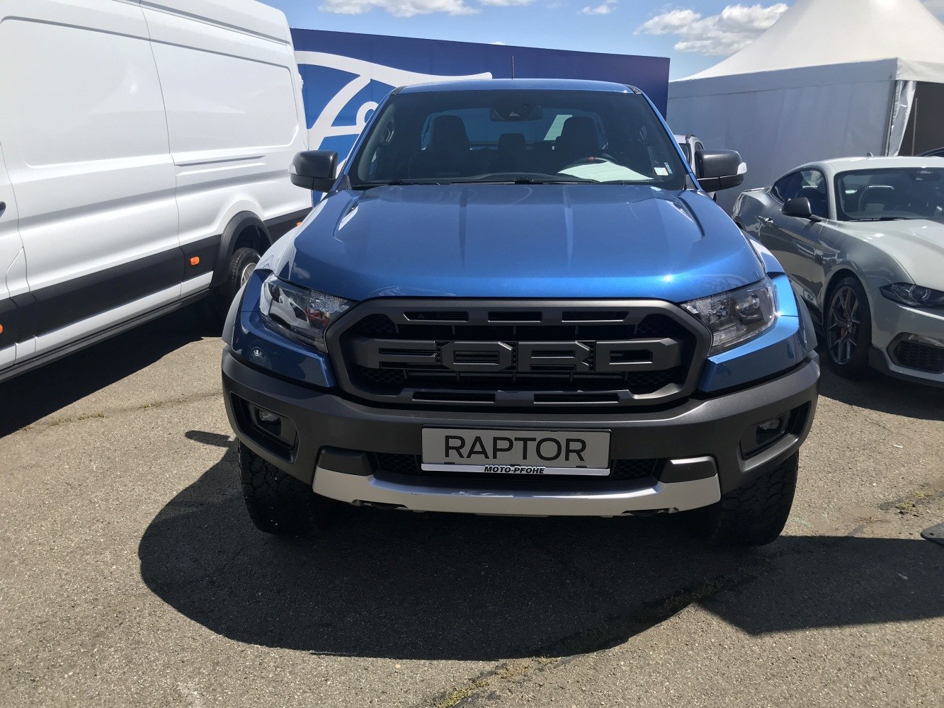 Bold grille and rugged headlights with off-road tires of a pickup truck front.
