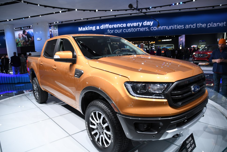 Front side view of a modern pickup truck with rugged tires and LED headlights
