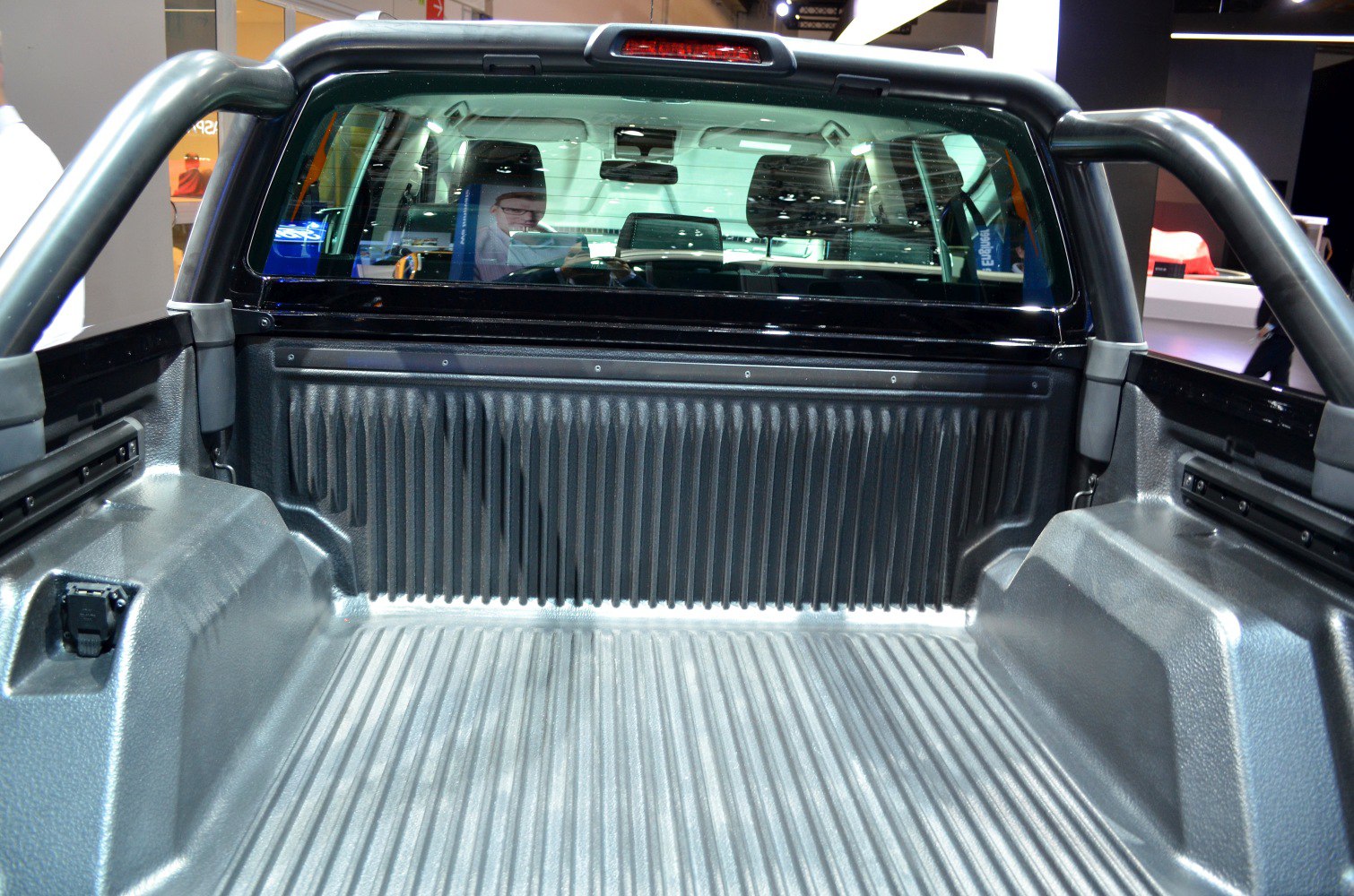 Pickup truck bed with protective liner and roll bar