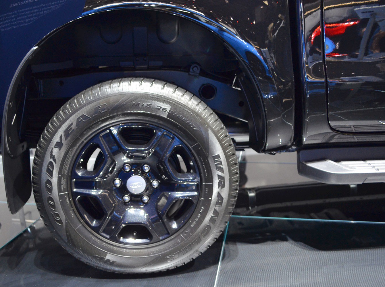 Black alloy wheel and Goodyear tire with fender and side step.