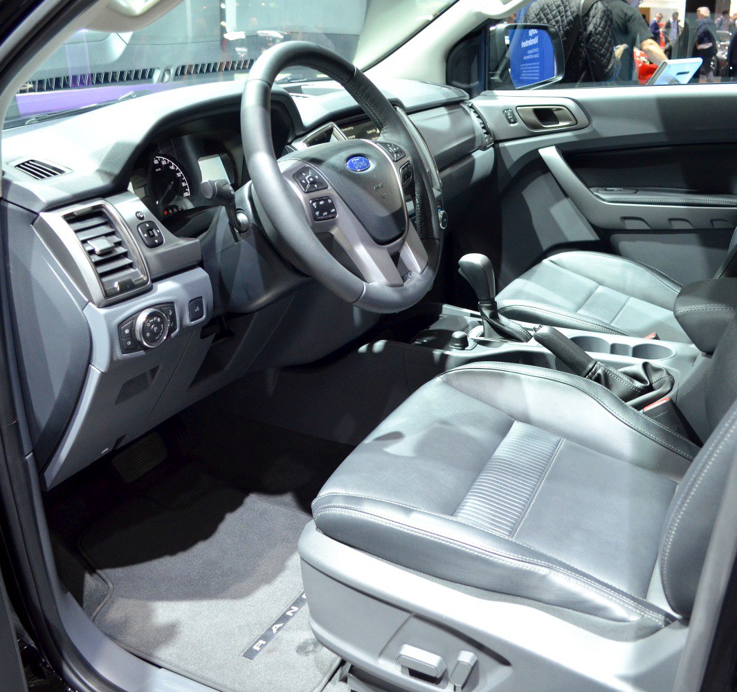 Interior of a vehicle focusing on steering, dashboard, and front seats